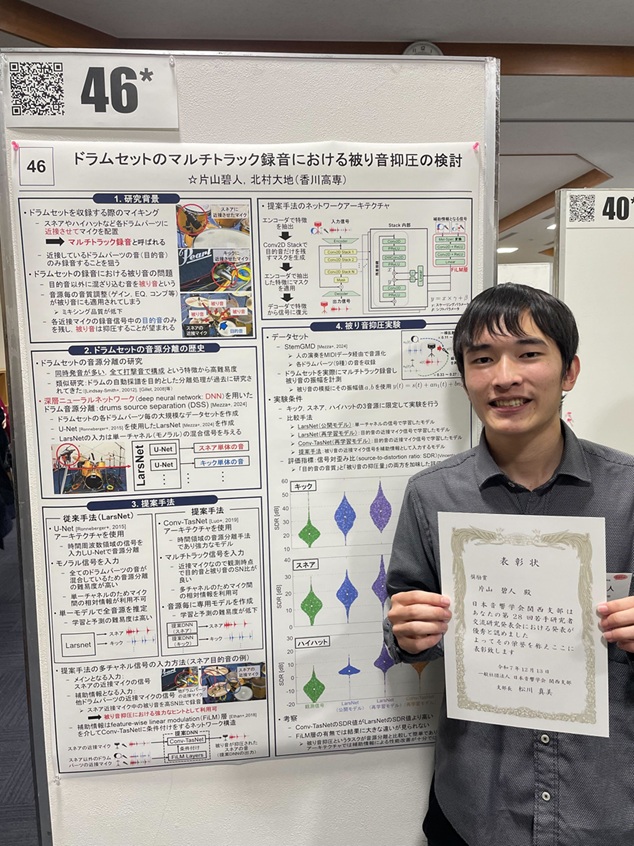 ポスターの前で賞状を掲げる片山君